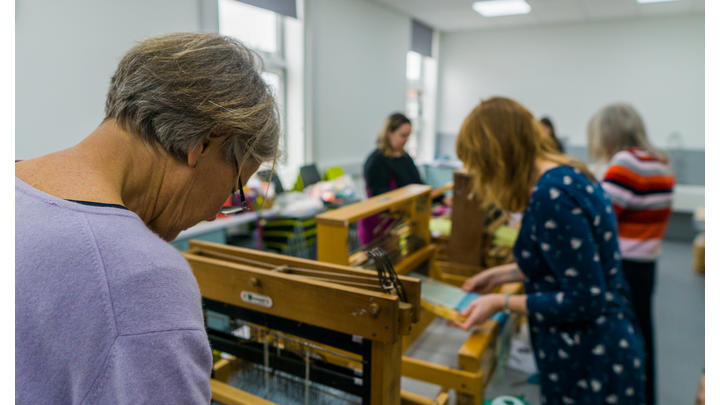 Women in a library weaving
