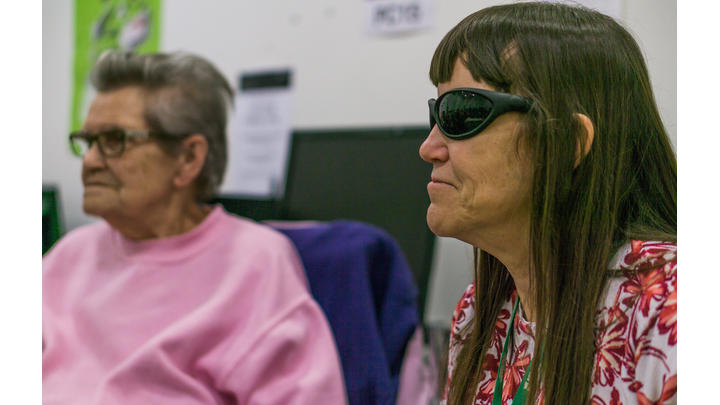 A blind and partially sighted woman in a library