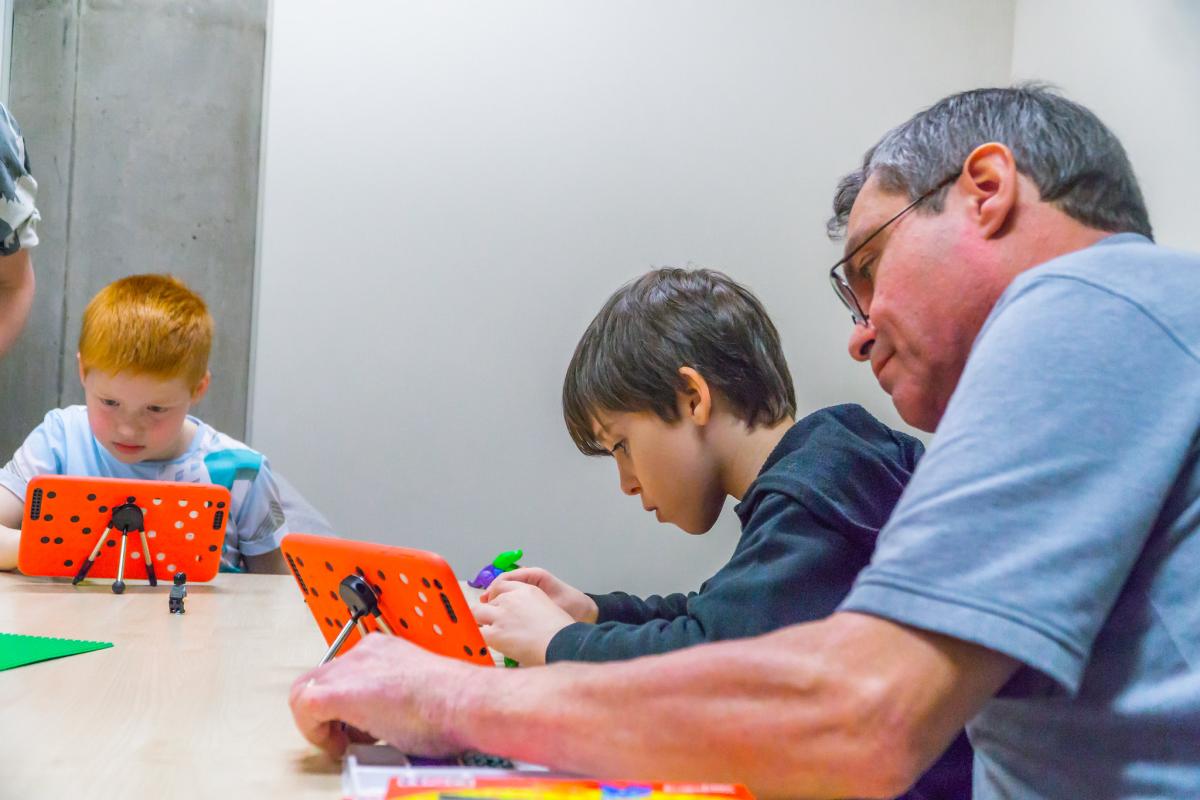 Children working on tablets in a library Children working on tablets in a library