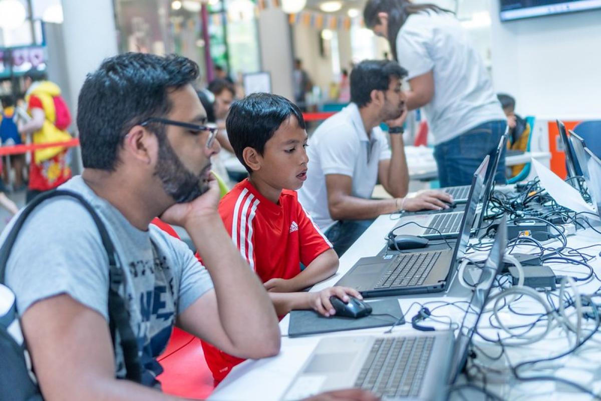 A man and boy study a computer screen in a library. A man and boy study a computer screen in a library.