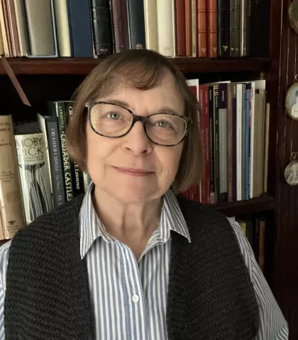 Carole Knowles is photographed standing in front of bookshelves.