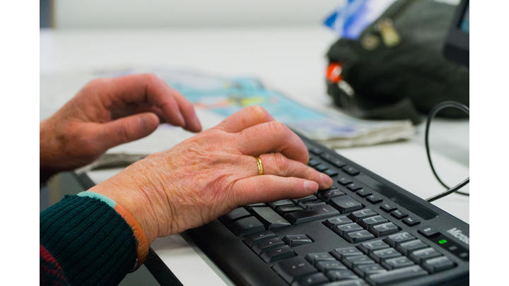 Elderly woman's hands on a keyboard