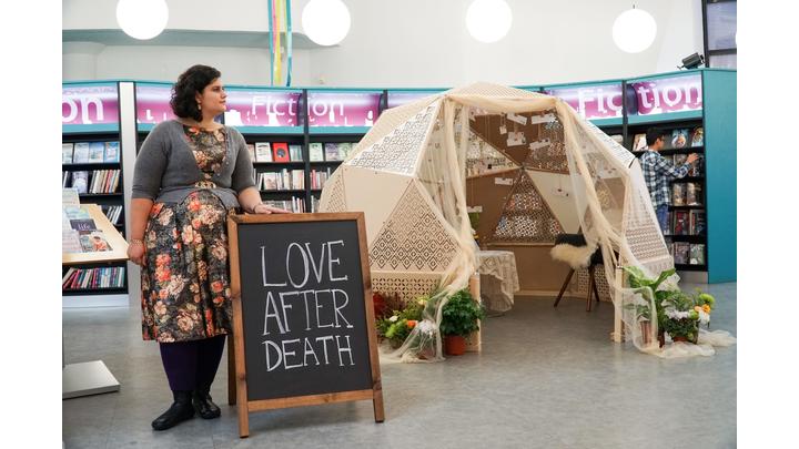 Woman next to chalkboard that says love after death