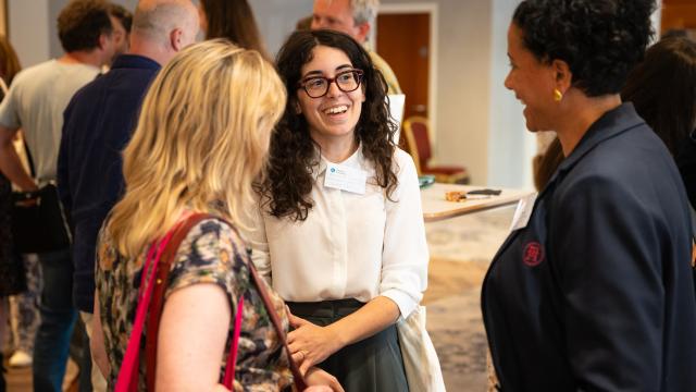 People chatting and smiling at a networking event.