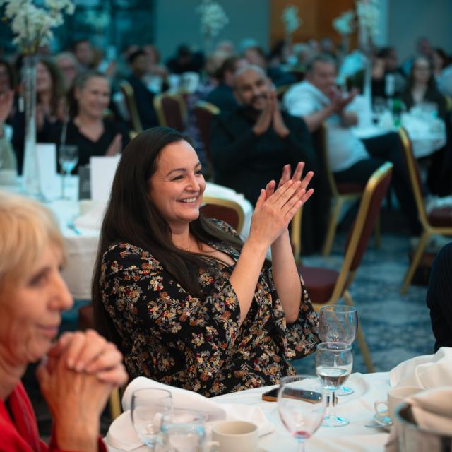 People in audience smiling and clapping