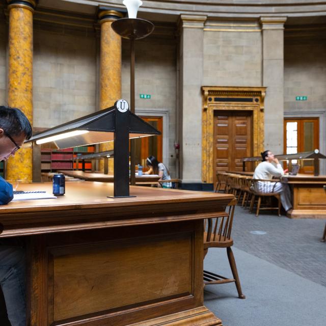 A man studies a document in a library.