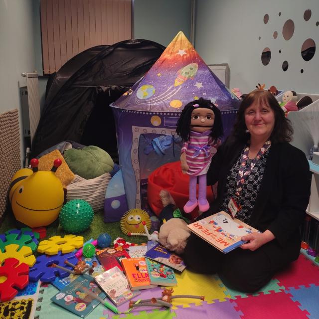 Anna Brader is seen holding a children's book.