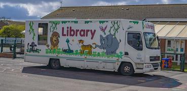 A mobile library vehicle decorated with cartoon animals